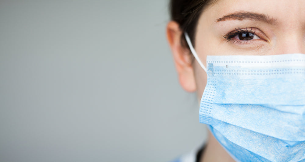 Close up of female UK EMS doctor's face,wearing blue PPE surgical protective mask